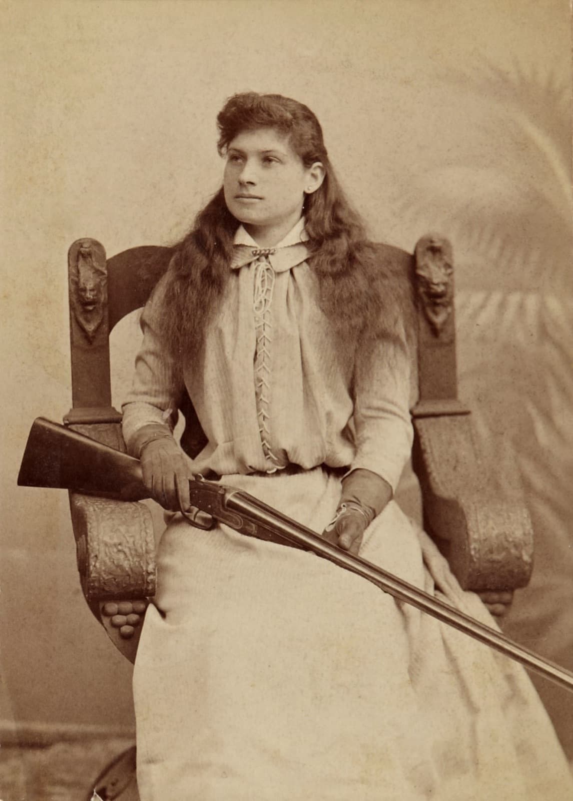 Annie Oakley holding a rifle, around 1880