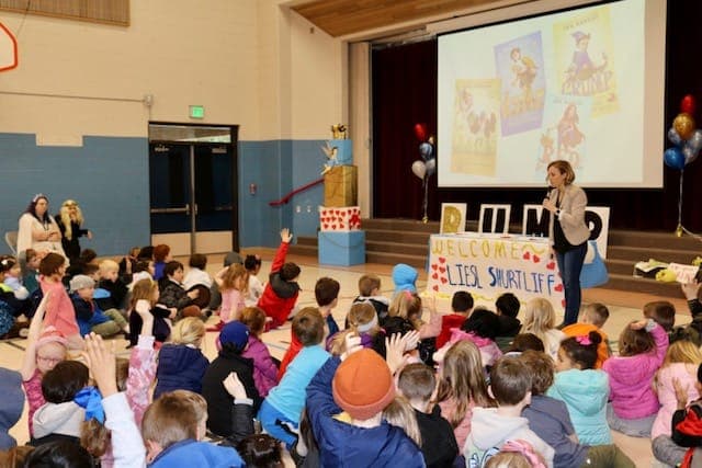 Students raising their hands at one of Liesl’s assemblies