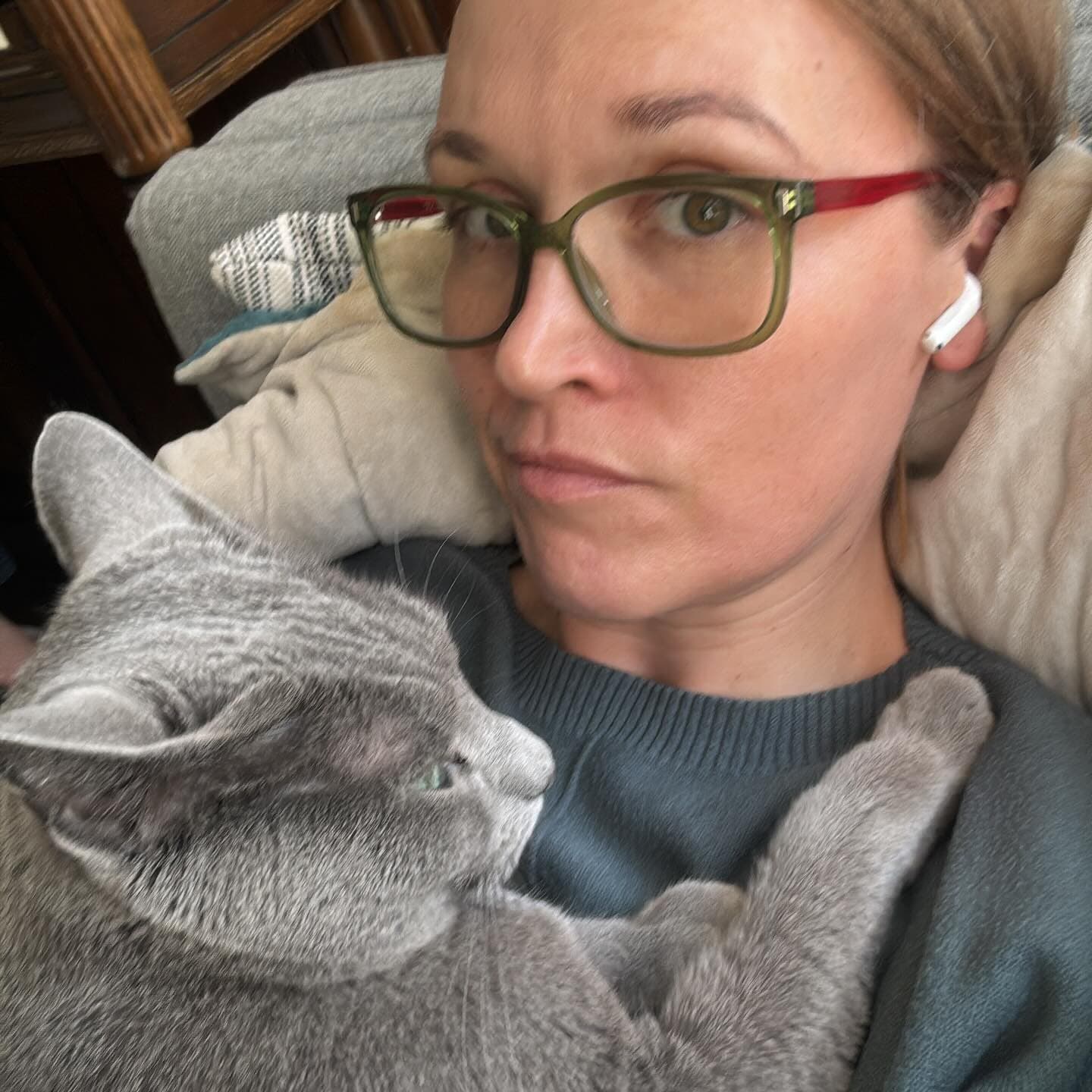 Instagram post: Liesl relaxing at home with her gray cat curled up on her