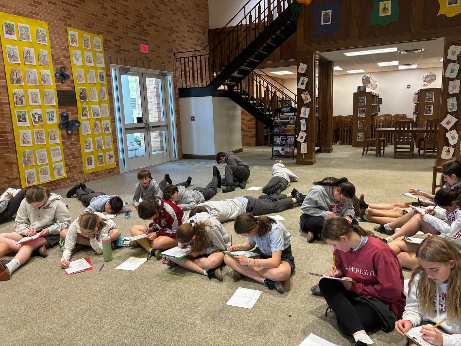 Students writing on the library floor