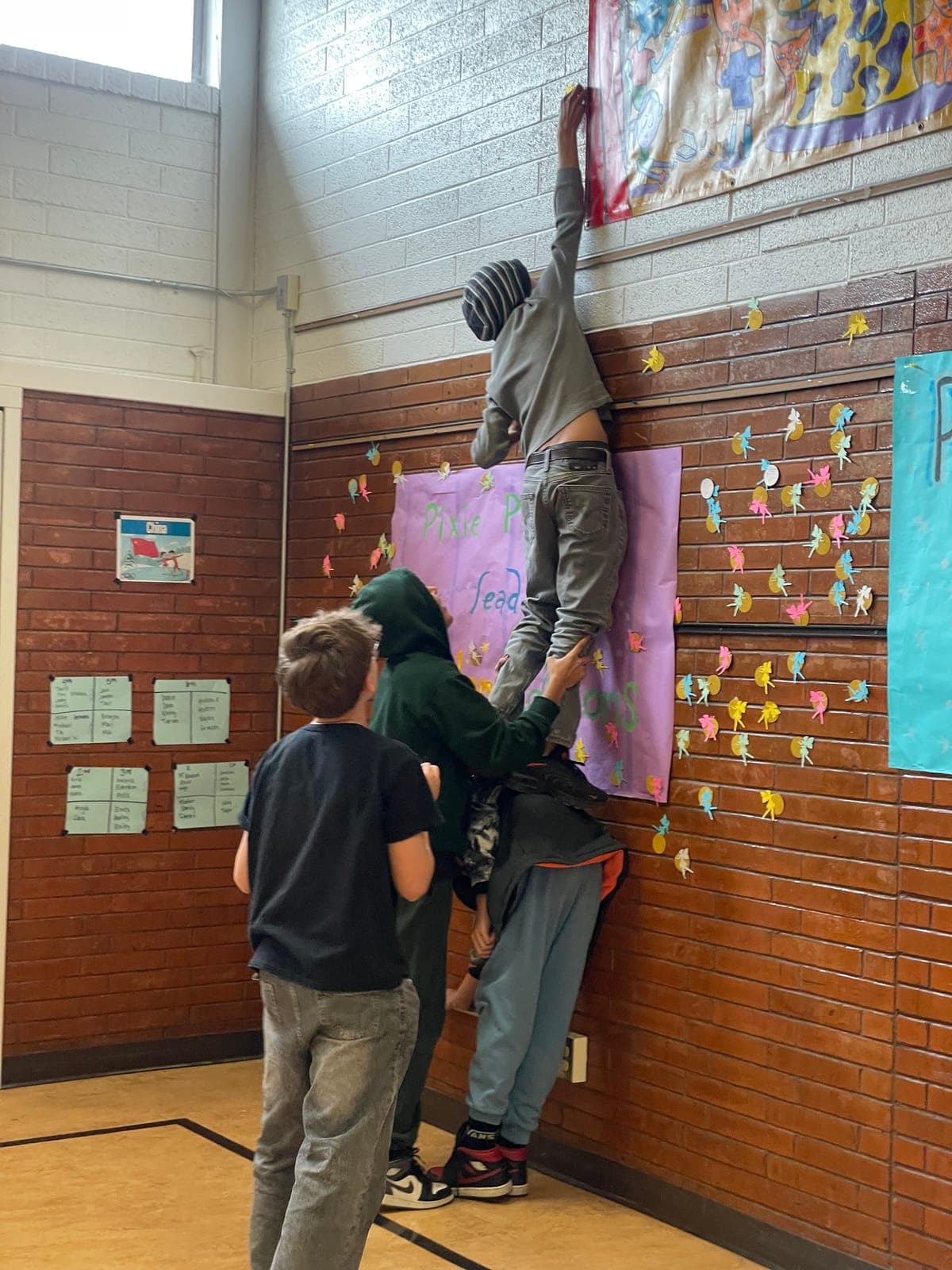 Students hanging a reading display in a school hallway